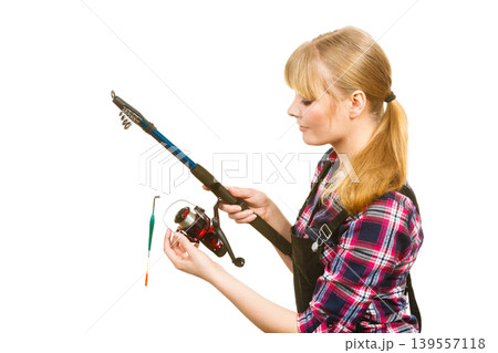 Woman in shirt looking at fishing rod Woman in shirt looking at fishing rod 139557118