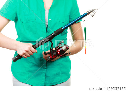 Person holding fishing rod, spinning equipment. Person holding fishing rod, spinning equipment. 139557125