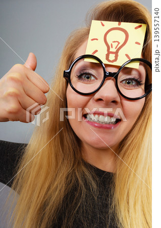Woman having light bulb mark on forehead thinking 139557140