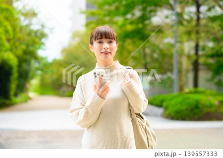 スマホを持つ女性、緑の中 139557333