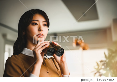 双眼鏡を覗く女性の横顔 双眼鏡を覗く女性の横顔 139557462