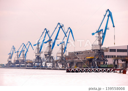 Frozen Industrial Harbor With Blue Cargo Cranes 139558008