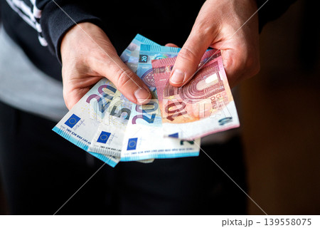 Hands Holding Euro Banknotes Close Up Hands Holding Euro Banknotes Close Up 139558075