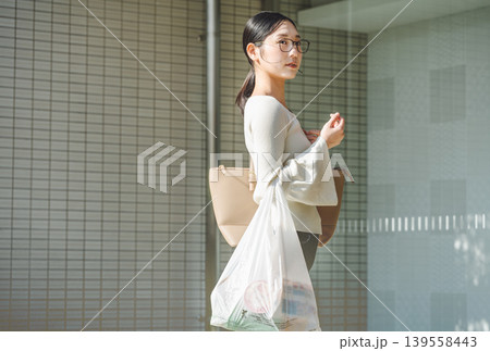 お買い物から自宅のマンションへ帰る若い女性 139558443
