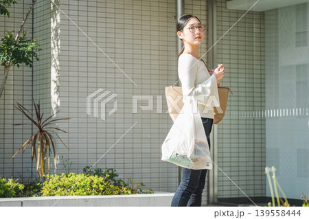 お買い物から自宅のマンションへ帰る若い女性 お買い物から自宅のマンションへ帰る若い女性 139558444
