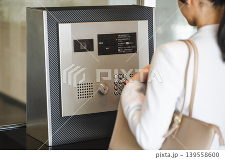 マンションのオートロックのボタンを押す女性 マンションのオートロックのボタンを押す女性 139558600
