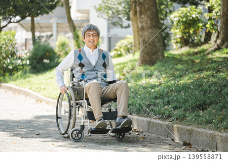 公園を車椅子で散歩するシニア男性 139558871