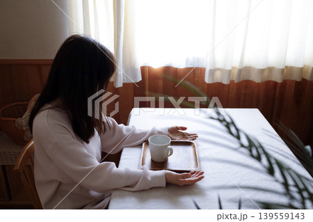 髪も整えず部屋着のまま座って瞑想する女性　朝にゆっくり調子を整えるイメージ 139559143
