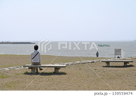 静かな海を見つめる人　穏やかな水面と青空に癒やされる静寂のひととき 139559474