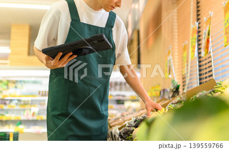 スーパーで働く店員がタブレットを確認する スーパーで働く店員がタブレットを確認する 139559766