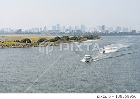 都会を背に走るボート　高層ビル群を望むベイエリアの開放感あふれる水上風景 139559956
