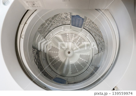 少し汚い縦型洗濯機の洗濯槽を上から見た様子 139559974