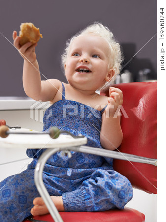 Child, high chair and eating muffin, food and breakfast sweets at home in kitchen. Young kid, hungry toddler and cupcake dessert, sugar and pastry snack for happy cute girl in house in the morning Child, high chair and eating muffin, food and breakfast sweets at home in kitchen. Young kid, hungry toddler and cupcake dessert, sugar and pastry snack for happy cute girl in house in the morning 139560244