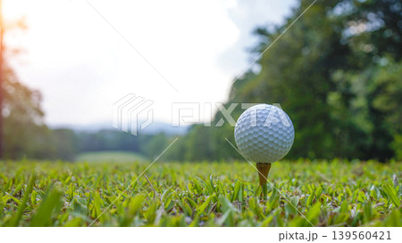 Golf ball on tee in a beautiful golf course with morning sunshine. Golf ball on tee in a beautiful golf course with morning sunshine. 139560421