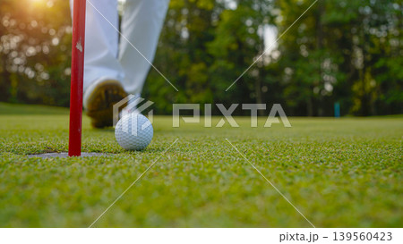 Golfers are putting golf in the evening golf course golf backglound. Golfers are putting golf in the evening golf course golf backglound. 139560423