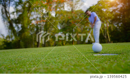 Golfers are putting golf in the evening golf course golf backglound. Golfers are putting golf in the evening golf course golf backglound. 139560425