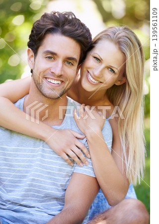 Couple, hug and portrait in park with smile, love and commitment in healthy relationship. People on date outdoor, happiness and care with trust, partner and bonding together for marriage and romance 139561109