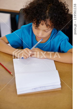 Student, thinking and child writing in notebook above desk with pencil, paper and learning in school. Kid, education and start of study on table in class with question or curiosity from lesson Student, thinking and child writing in notebook above desk with pencil, paper and learning in school. Kid, education and start of study on table in class with question or curiosity from lesson 139561138