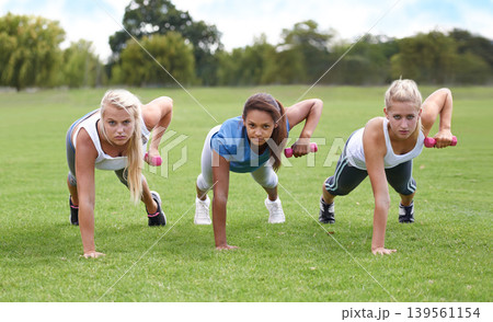 Teen, girl with dumbbells and push up for fitness and muscle, strong athlete group outdoor for sport and bodybuilding. Portrait, exercise equipment in park and bodybuilder team workout together Teen, girl with dumbbells and push up for fitness and muscle, strong athlete group outdoor for sport and bodybuilding. Portrait, exercise equipment in park and bodybuilder team workout together 139561154