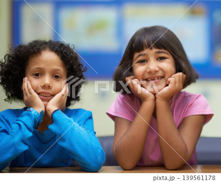 Students, children and portrait or happiness in classroom for learning, knowledge or education at desk. Kids, face and smile at academy or school with confidence or pride for development and friends 139561178