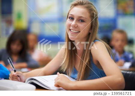Girl, classroom and writing in portrait for education, learning and notes for knowledge in high school. Female person, book and pride for assessment or test, studying lesson and happy at academy Girl, classroom and writing in portrait for education, learning and notes for knowledge in high school. Female person, book and pride for assessment or test, studying lesson and happy at academy 139561721