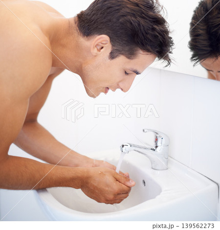 Man, washing face and water for hygiene in mirror, clean and cosmetics or skincare. Male person, bathroom and wellness in morning routine, reflection and grooming or self care and basin at home Man, washing face and water for hygiene in mirror, clean and cosmetics or skincare. Male person, bathroom and wellness in morning routine, reflection and grooming or self care and basin at home 139562273