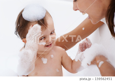Baby, bath and mother laughing in a bathroom with cleaning, foam and help with love and support. Care, mom and young child with soap in a home with bonding and washing for wellness and hygiene Baby, bath and mother laughing in a bathroom with cleaning, foam and help with love and support. Care, mom and young child with soap in a home with bonding and washing for wellness and hygiene 139562451