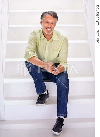 Man, portrait or phone on stairs in office for social network, download digital app or business contact in agency. Happy mature entrepreneur typing on smartphone, mobile notification or chat on steps Man, portrait or phone on stairs in office for social network, download digital app or business contact in agency. Happy mature entrepreneur typing on smartphone, mobile notification or chat on steps 139562452