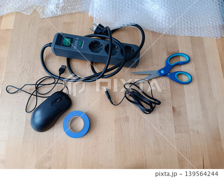 Packing supplies and power strip mouse scissors bubble wrap on wooden table 139564244