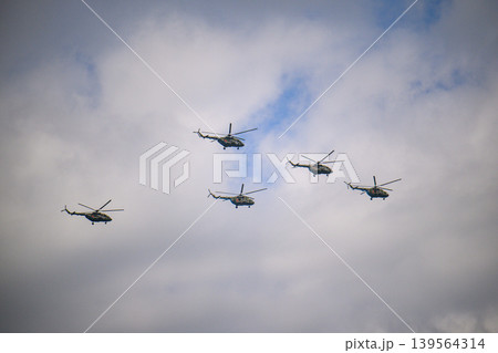 Helicopter squadron flying in coordinated pattern above overcast skies Helicopter squadron flying in coordinated pattern above overcast skies 139564314