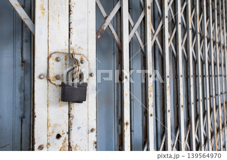 Vintage Folding Metal Gate and Padlock Security on Old Building Vintage Folding Metal Gate and Padlock Security on Old Building 139564970