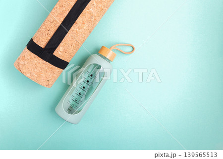 Yoga mat and water bottle on a blue background. 139565513