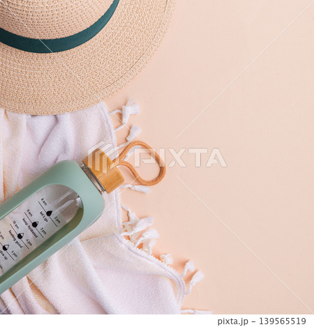 Beach hat, water bottle, and towel on a light background. 139565519
