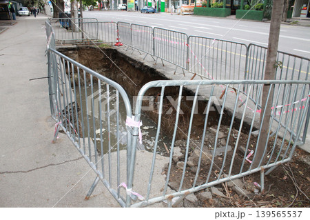 The hole in the road was created to repair underground utilities. The hole in the road was created to repair underground utilities. 139565537