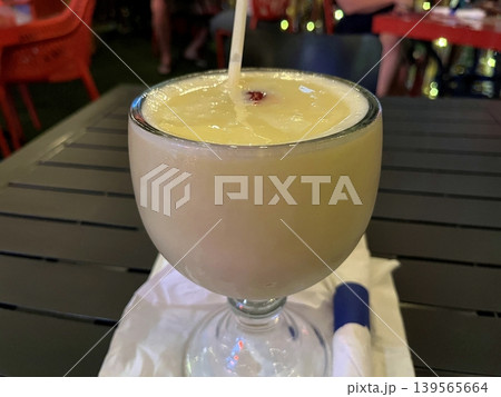 Glass of pina colada on a table. Glass of pina colada on a table. 139565664