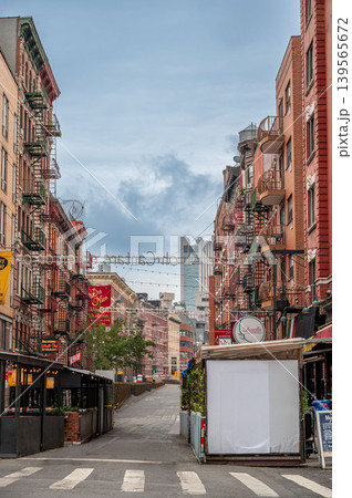 New york, usa august 17,2024. Mulberry street showing brick buildings with fire escapes and outdoor dining structures in little italy, manhattan, new york 139565672
