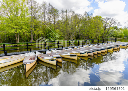 Outdoor recreation area with rowing boats and wooden pier. Outdoor recreation area with rowing boats and wooden pier. 139565801