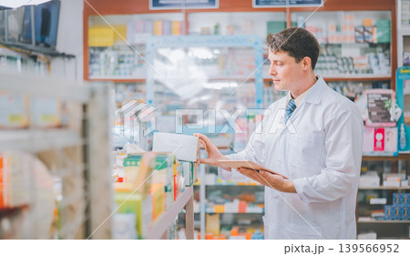 Pharmacist checking Checks Inventory of Medicine, Drugs, Vitamins with tablet and checking patient's prescription in modern pharmacy Pharmacist checking Checks Inventory of Medicine, Drugs, Vitamins with tablet and checking patient's prescription in modern pharmacy 139566952