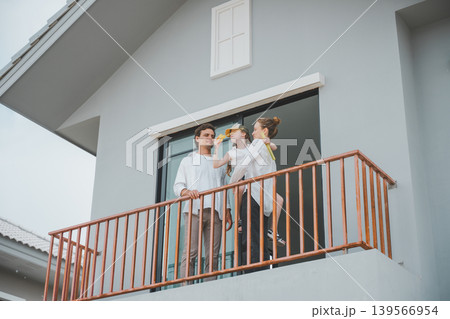 Happy family standing together on balcony of new home enjoying quality time 139566954