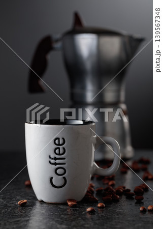 Cup of espresso and classic Italian aluminium moka pot on a black background. Cup of espresso and classic Italian aluminium moka pot on a black background. 139567348