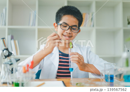 Asian male science students looking through a microscope and tests of plants in the classroom. Learning about scientific experiments on plant species. Asian male science students looking through a microscope and tests of plants in the classroom. Learning about scientific experiments on plant species. 139567562