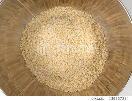 Sesame seeds pile closeup, white small benne grains. Sesamum indicum fruits Sesame seeds pile closeup, white small benne grains. Sesamum indicum fruits 139567854