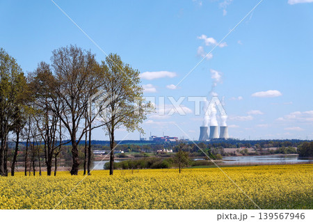 Cooling towers with steam on sky at nuclear power plant with pond and trees nature foreground, Temelin, Czech Republic, energy self-sufficiency, greenhouse emission reduction, global warming concept Cooling towers with steam on sky at nuclear power plant with pond and trees nature foreground, Temelin, Czech Republic, energy self-sufficiency, greenhouse emission reduction, global warming concept 139567946