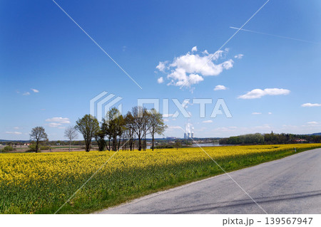 Cooling towers with steam on sky at nuclear power plant with pond and trees nature foreground, Temelin, Czech Republic, energy self-sufficiency, greenhouse emission reduction, global warming concept 139567947