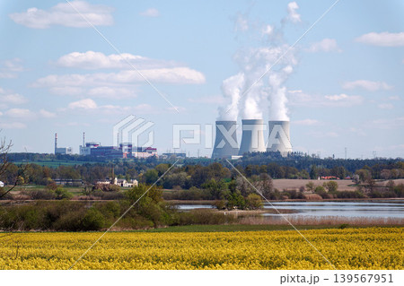 Cooling towers with steam on sky at nuclear power plant with pond and trees nature foreground, Temelin, Czech Republic, energy self-sufficiency, greenhouse emission reduction, global warming concept Cooling towers with steam on sky at nuclear power plant with pond and trees nature foreground, Temelin, Czech Republic, energy self-sufficiency, greenhouse emission reduction, global warming concept 139567951