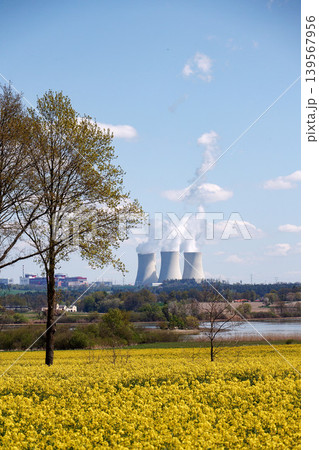 Cooling towers with steam on sky at nuclear power plant with pond and trees nature foreground, Temelin, Czech Republic, energy self-sufficiency, greenhouse emission reduction, global warming concept Cooling towers with steam on sky at nuclear power plant with pond and trees nature foreground, Temelin, Czech Republic, energy self-sufficiency, greenhouse emission reduction, global warming concept 139567956