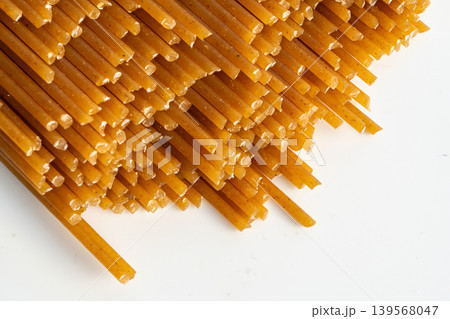 Raw wholegrain brown spaghetti macro texture, dry spagetti pattern Raw wholegrain brown spaghetti macro texture, dry spagetti pattern 139568047