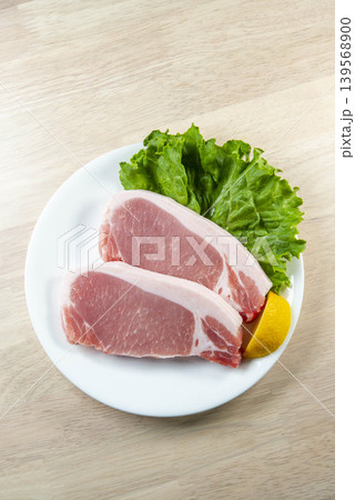 豚肉ステーキとレタスをフレッシュレモンで彩った白い皿の食卓 豚肉ステーキとレタスをフレッシュレモンで彩った白い皿の食卓 139568900