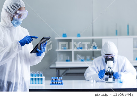 Scientist man look into Microscope research in science laboratory. Asian scientist looking equipment laboratory chemistry labs. Covid-19 coronavirus biochemistry research experiment vaccine concept 139569448