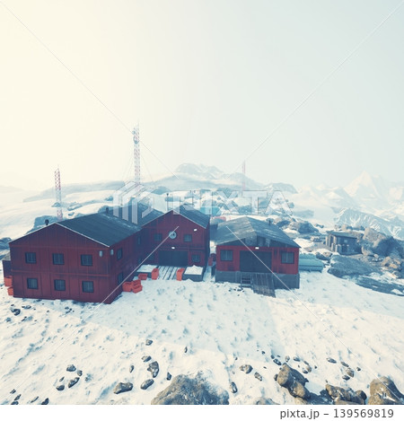Nestled in a serene winter landscape, this remote lodge boasts red wooden structures amid vast snow covered terrain. Communication towers stand tall in the distance, enhancing its isolation. Nestled in a serene winter landscape, this remote lodge boasts red wooden structures amid vast snow covered terrain. Communication towers stand tall in the distance, enhancing its isolation. 139569819